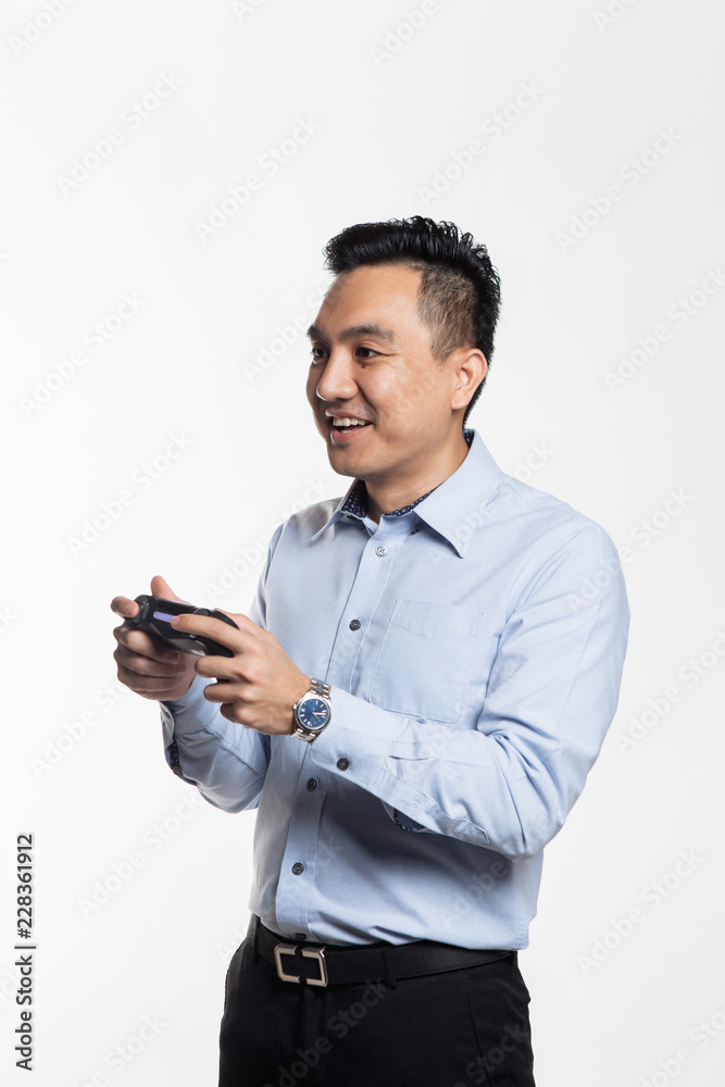 Asian man in work cloth playing console game Asian man in work cloth playing console game