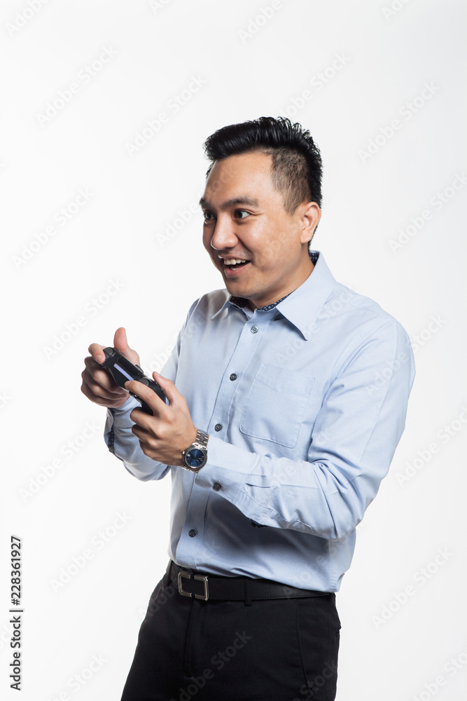 Asian man in work cloth playing console game Asian man in work cloth playing console game