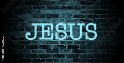 first name Jesus in blue neon on brick wall