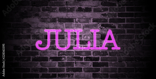 first name Julia in pink neon on brick wall