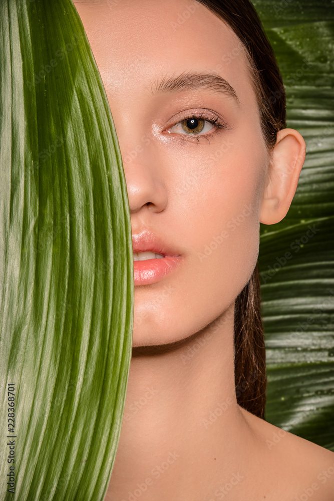 Fototapeta premium Beautiful brunette woman closeup with plants