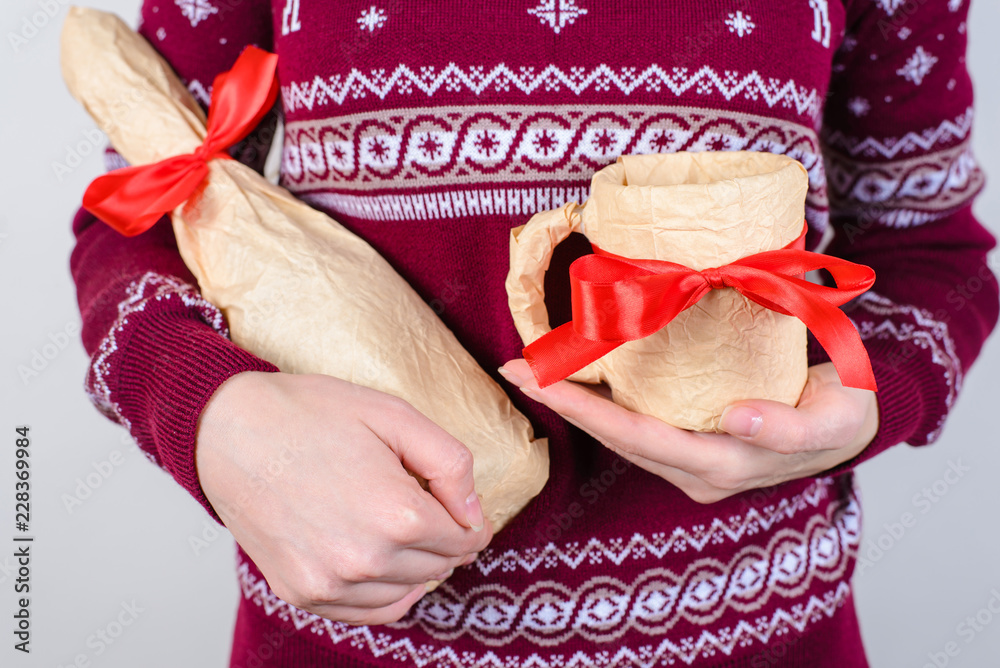 Generous secret santa giving presents to everybody concept. Cropped close up photo portrait of woman's hands holding two nice packed in craft paper presents isolated on grey background
