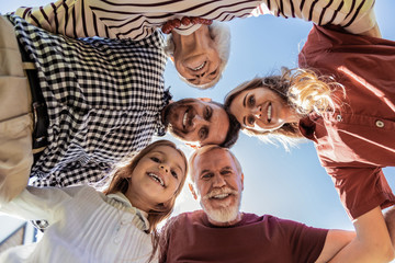 Playful mood. Cheerful mature man feeling happiness while embracing his family