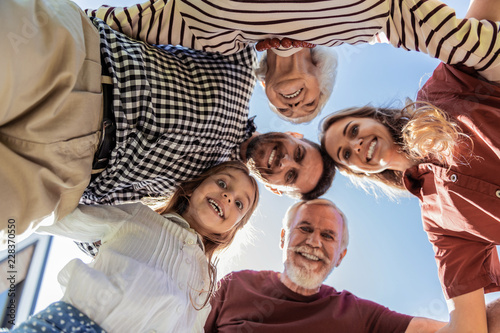Gather at time. Delighted brunette bearded man keeping smile on his face while looking downwards