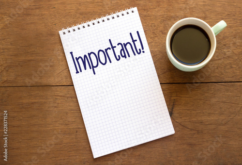 Important text on notebook with coffee cup on wooden table