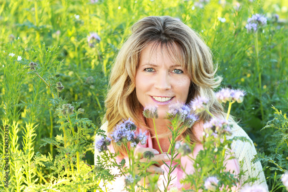 Face of an attractive mature woman in a lilac flowerfield Face of an attractive mature woman in a lilac flowerfield