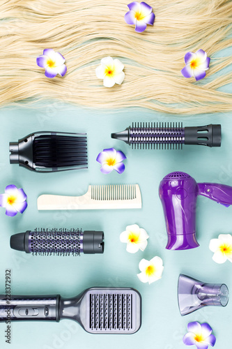 Hairdressing tools and hair extensions on blue wooden background. Top view