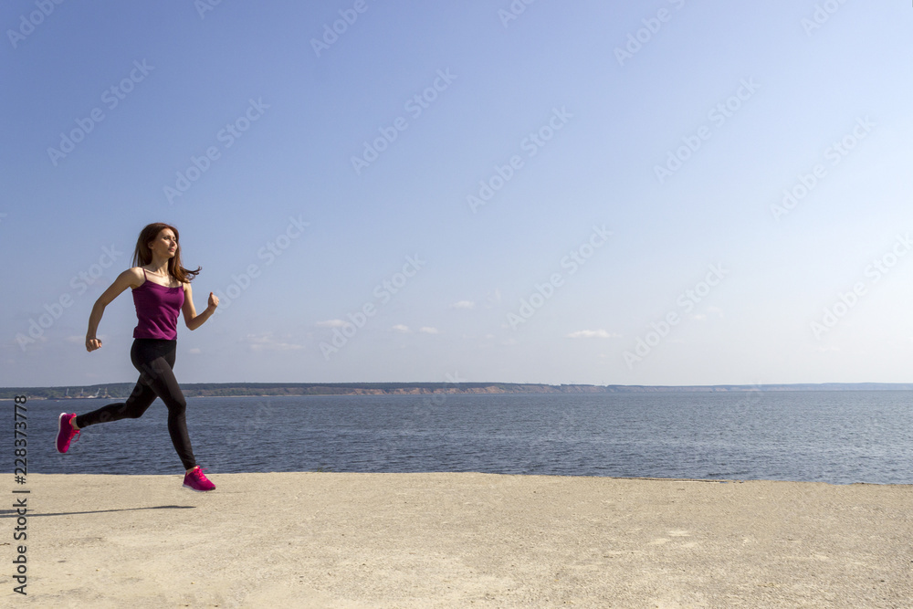 Young fit girl running and training on the beach