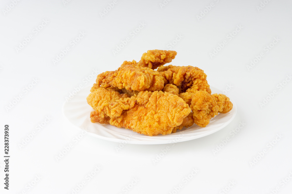 Fried breaded chicken fillet isolated on white background with selective focus and crop fragment Fried breaded chicken fillet isolated on white background with selective focus and crop fragment