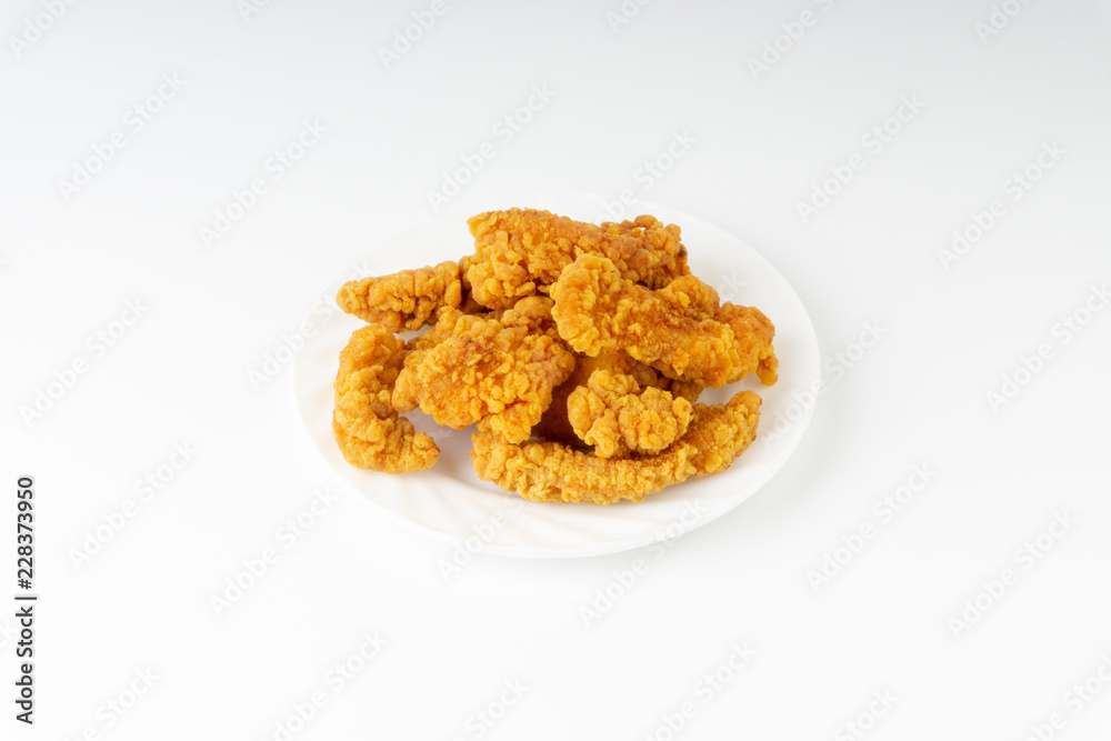 Fried breaded chicken fillet isolated on white background with selective focus and crop fragment Fried breaded chicken fillet isolated on white background with selective focus and crop fragment