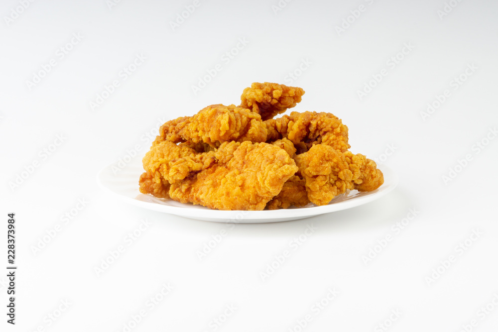 Fried breaded chicken fillet isolated on white background with selective focus and crop fragment Fried breaded chicken fillet isolated on white background with selective focus and crop fragment
