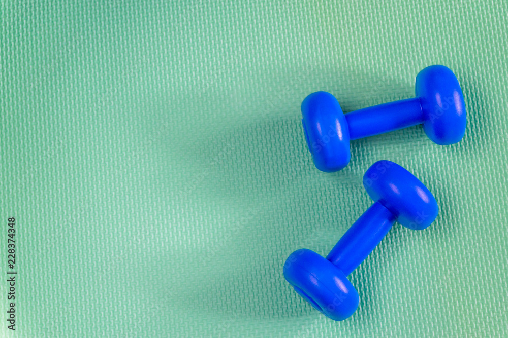 little blue dumbbells against a bright background