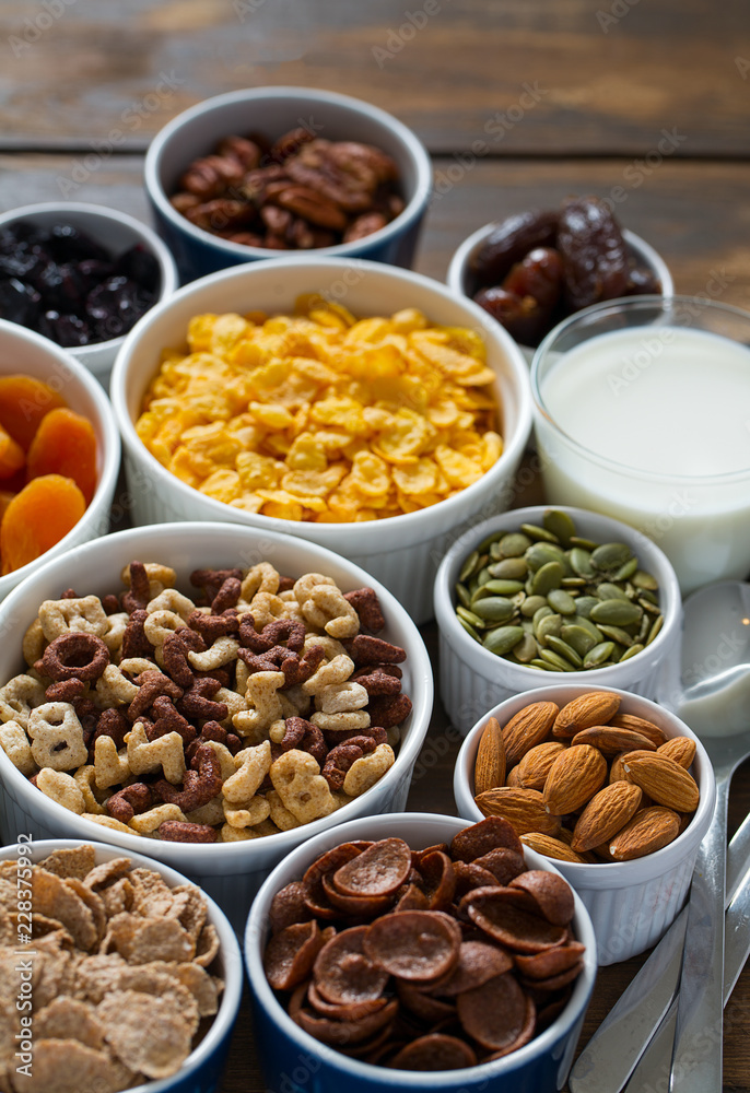 various cereals, nuts and dried fruits on wooden surface