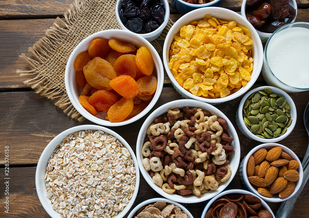 various cereals, nuts and dried fruits on wooden surface various cereals, nuts and dried fruits on wooden surface