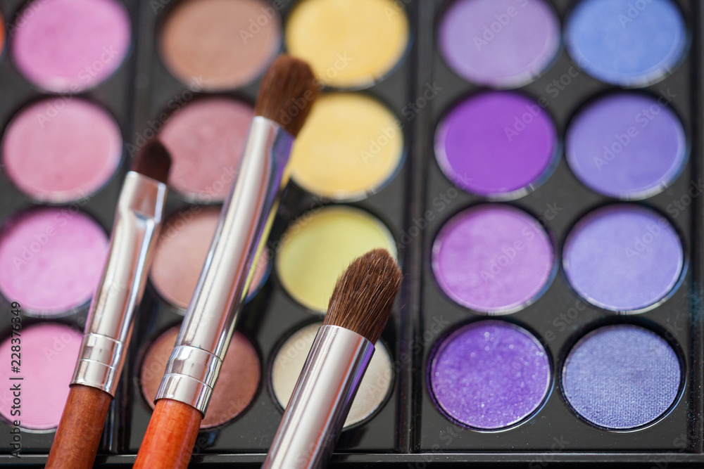 Makeup brushes on background with colorful powder. Macro shooting. Makeup brushes on background with colorful powder. Macro shooting.