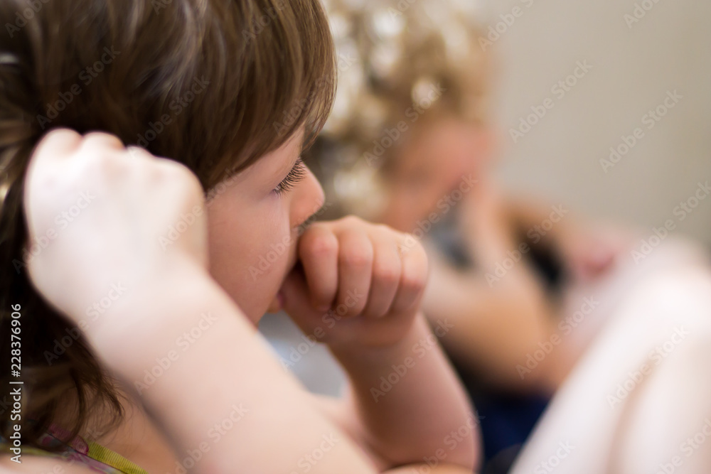 The little girl eats at the restaurant with cutlery