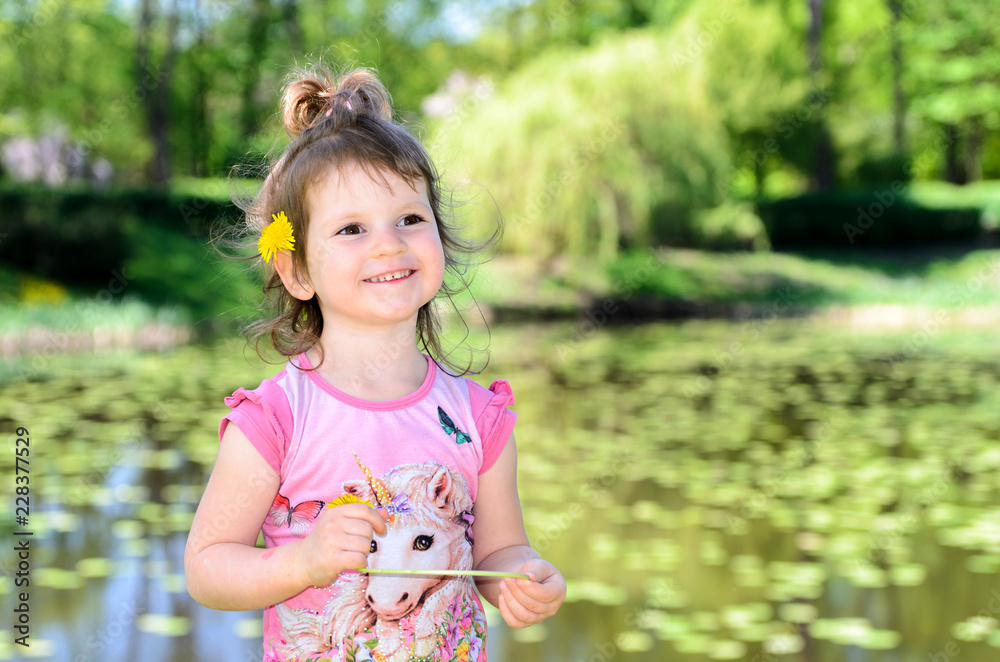 Portrait of a small three year old caucasian girl in a park Portrait of a small three year old caucasian girl in a park