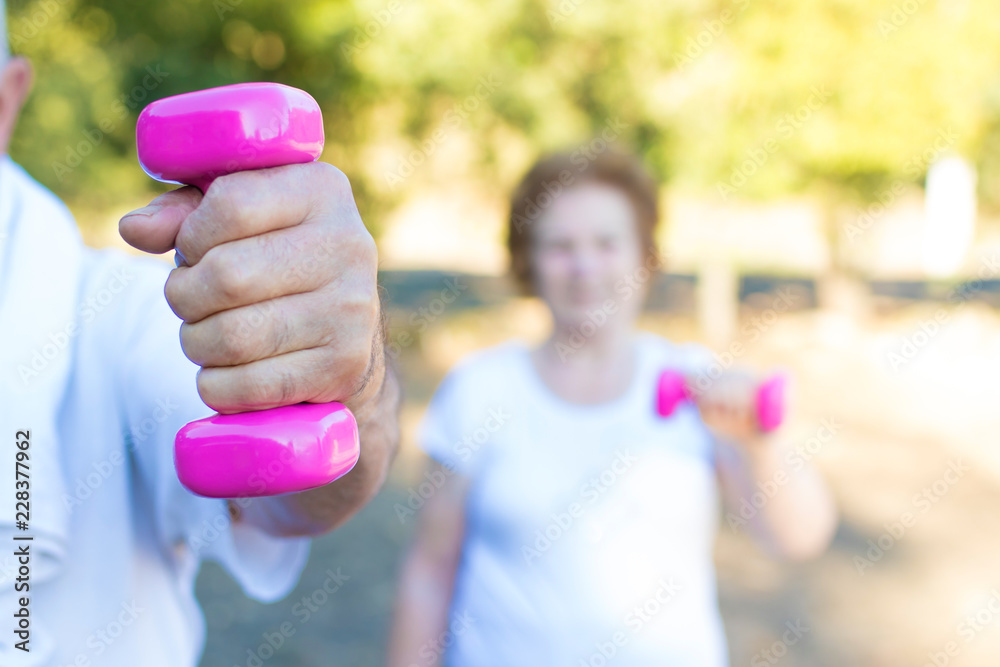 close-up of the hand with dumbbell of older doing sport close-up of the hand with dumbbell of older doing sport