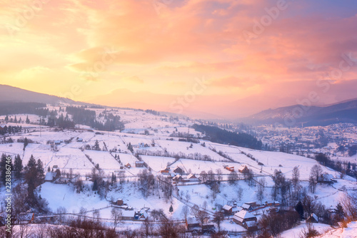 Beautiful winter landscape in soft sunset light, alpine valley surrounded by wooded mountains, Carpathians