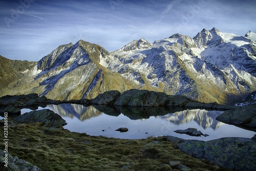 Great view of small lake in Gran Paradiso National Park   Alps  Italy   beautiful world. calm scenery with mountains covered by snow in background  majestic mountain landscape  wallpaper