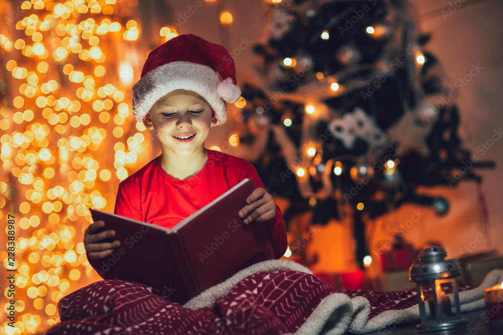 Surprised child opening magic Christmas book. Xmas holiday concept Surprised child opening magic Christmas book. Xmas holiday concept