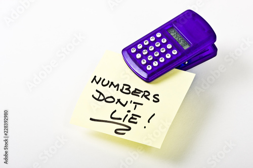 A clip-on calculater holding a note reading 