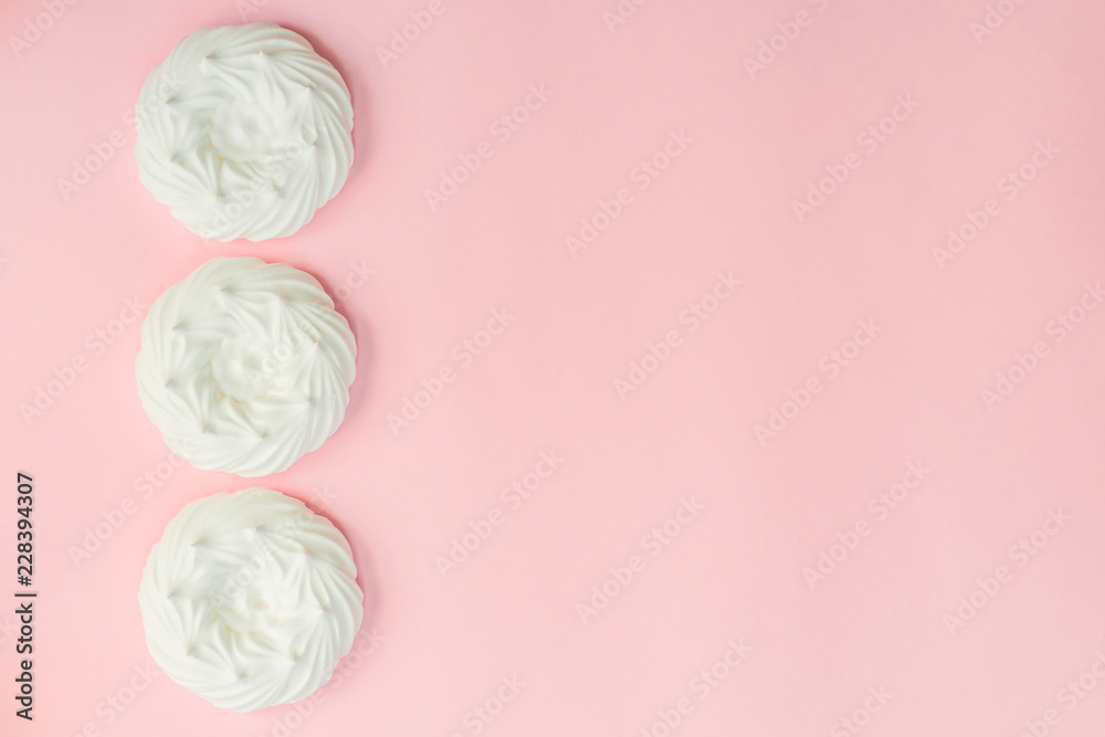 top view of homemade white air meringues on pink background top view of homemade white air meringues on pink background