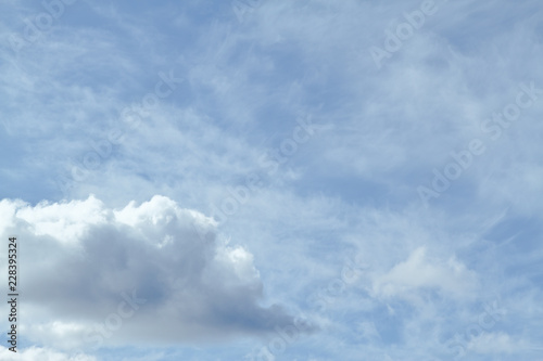 Blue sky filled with cirrus clouds and one cumulus cloud in the lower left.