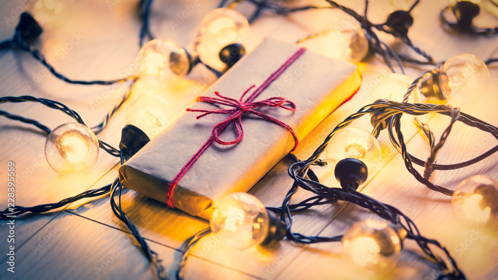 Christmas gift and fairy lights around it Christmas gift and fairy lights around it