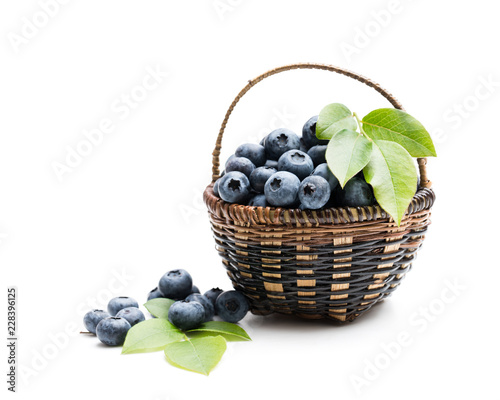 Fresh blueberries in small wicker basket isolated on white