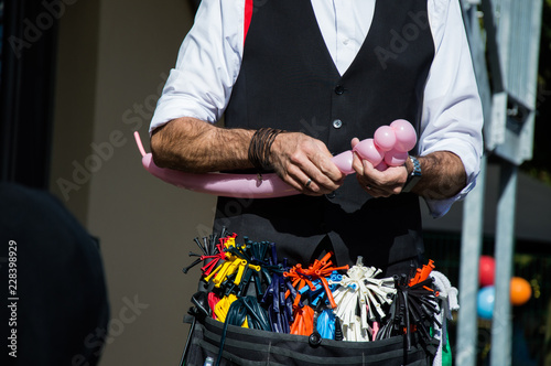 wizard creating a pink bear out of a balloon at a children's party