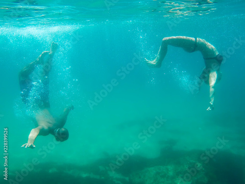 Young couple swimming in a transparent ocean water in Spain