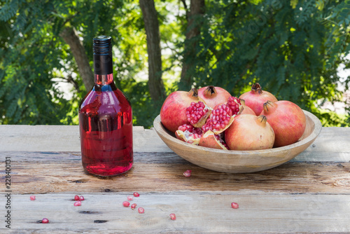 Botella con licor rojo y las fruta del granado photo