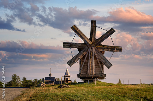 Kizhi Island, Russia, Karelia. A view of the wooden mill and the ancient religious architecture of the Kizhi Pogost. Summer landscape.