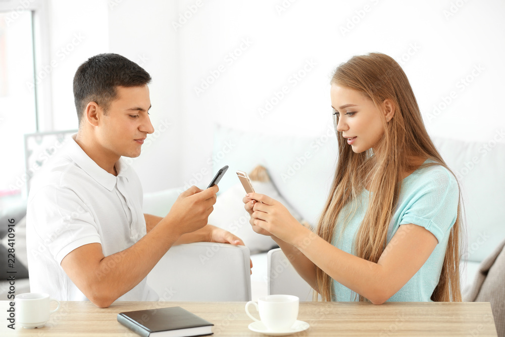 Young couple with mobile phones at home Young couple with mobile phones at home
