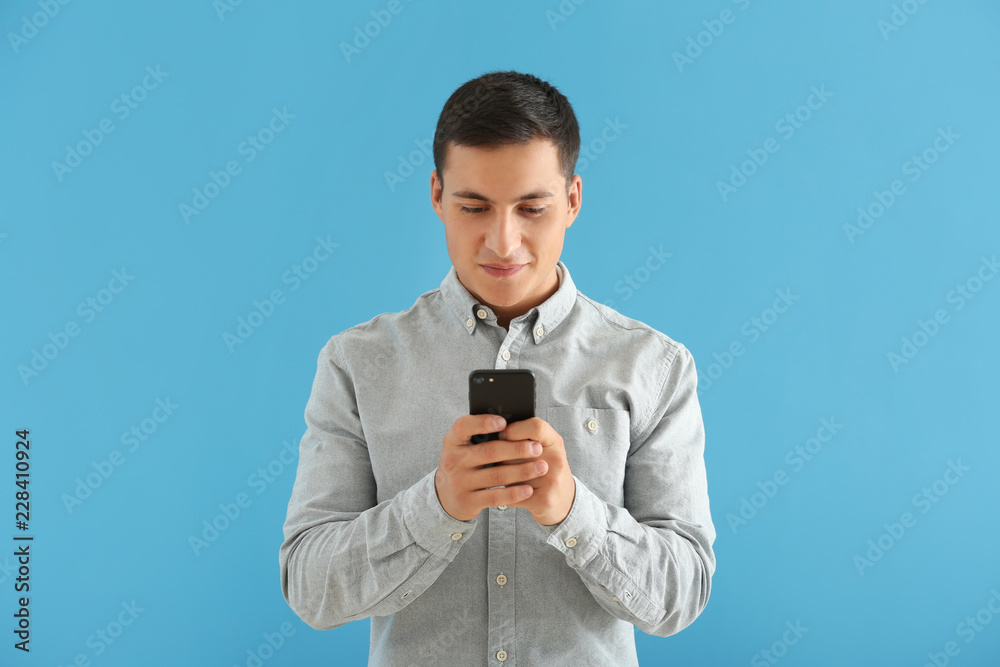 Young man with mobile phone on color background Young man with mobile phone on color background