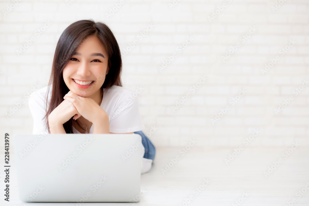 Beautiful portrait asian woman working online laptop lying on floor brick cement background, freelance girl using notebook computer with connect to internet, business and lifestyle concept. Beautiful portrait asian woman working online laptop lying on floor brick cement background, freelance girl using notebook computer with connect to internet, business and lifestyle concept.