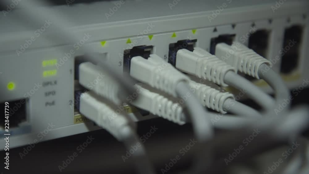 Closeup view of modern server computer with plenty of cables in rack with indicators blinking Closeup view of modern server computer with plenty of cables in rack with indicators blinking