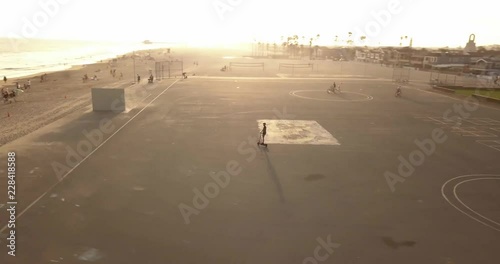 A flight over a Southern California Beach at sunset with a person riding an electronic scooter. photo