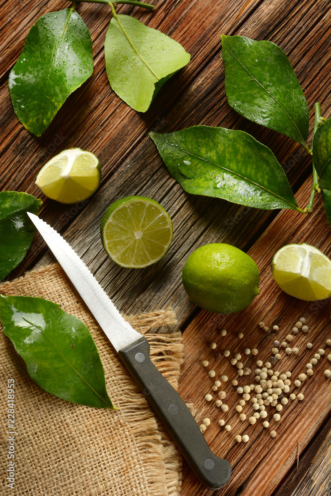 lime fruits with leaves on wooden table - tropical fruit with antioxidant properties lime fruits with leaves on wooden table - tropical fruit with antioxidant properties