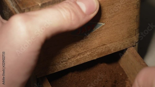 Man opens an old coffee grinder with ground coffee JAPY Grinder photo