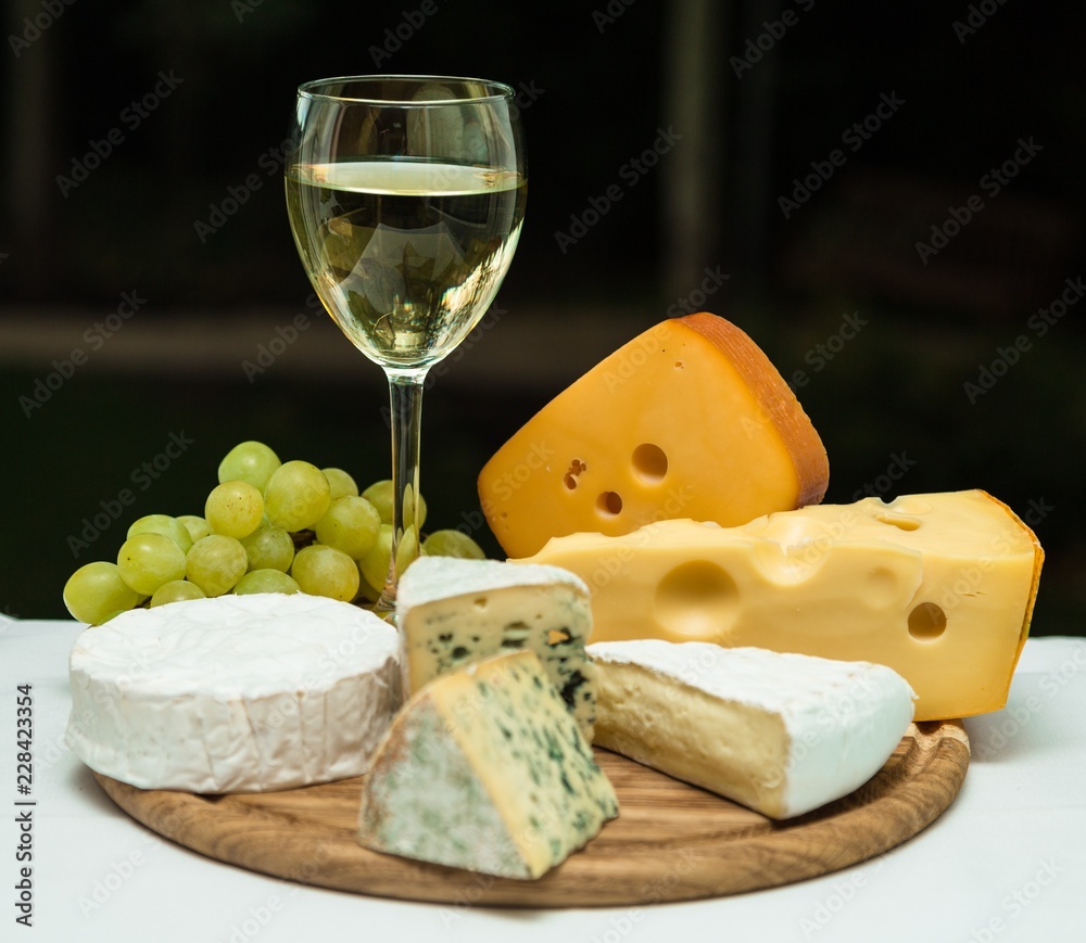 Wine Glass, Cheeses and Grape on the Wooden Platter Wine Glass, Cheeses and Grape on the Wooden Platter