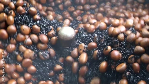 Close-up Chestnut roasted machine working chestnut seeds, By using heat and sand, the electric motor rotates to act as a stirring tank to make every chestnuts ripe.