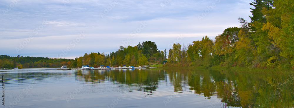 Beautiful Minnesota lake with reflection of marina and boats on cloudy day