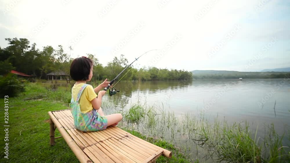 Happy girl pulling rod while fishing against landscape of lake. Happy girl pulling rod while fishing against landscape of lake.