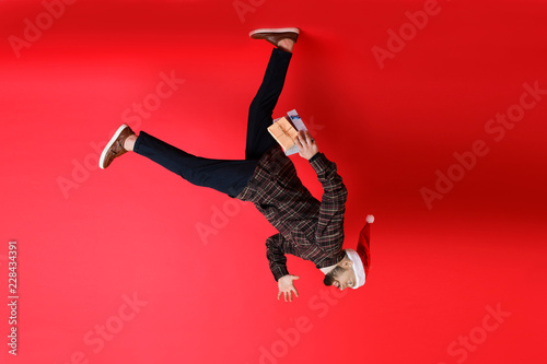 Young man running on ceiling while delivering Christmas gifts photo