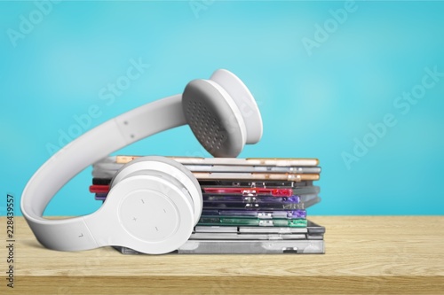 Headphones and compact discs on wooden background