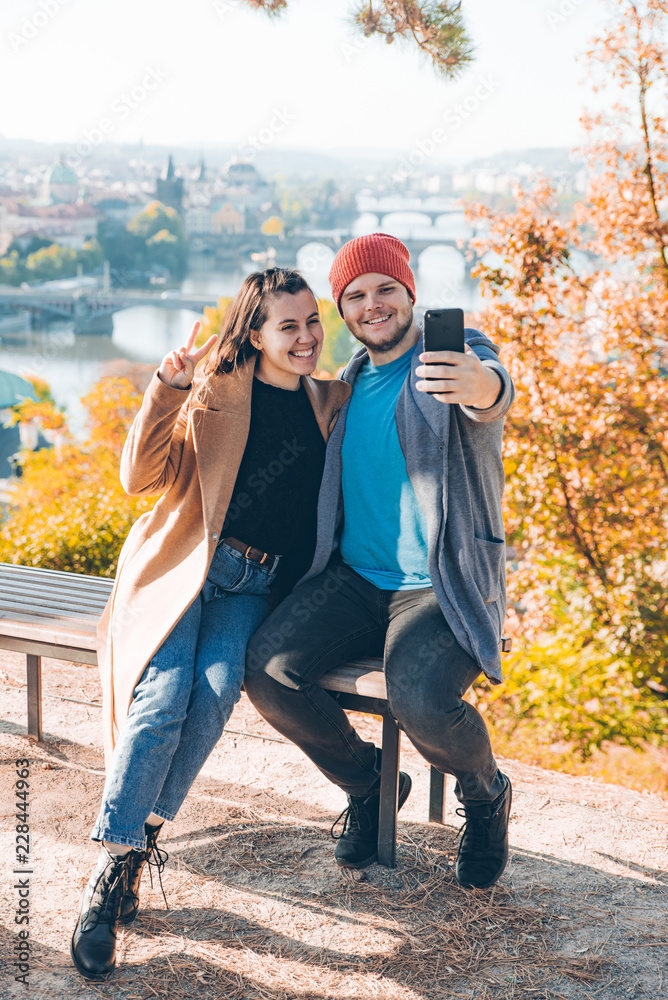 Obraz premium couple taking selfie on phone. autumn prague on background