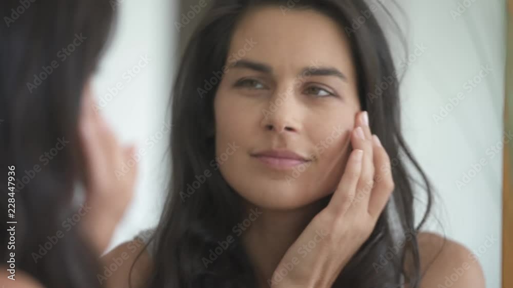 Close up of brunette woman looking in the mirror Close up of brunette woman looking in the mirror