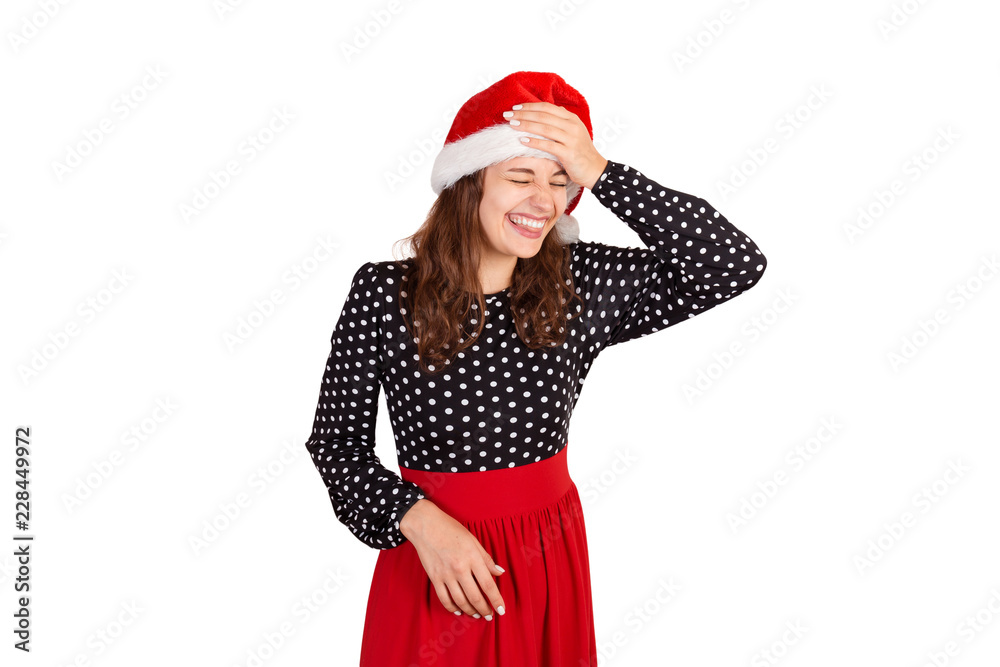 Fabulous joyful woman showing tongue and looking down laughs put hand on forehead. emotional girl in santa claus christmas hat isolated on white background. holiday concept Fabulous joyful woman showing tongue and looking down laughs put hand on forehead. emotional girl in santa claus christmas hat isolated on white background. holiday concept
